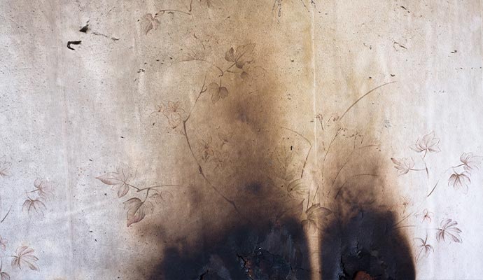 Fire smoke soot damage on room wallpaper