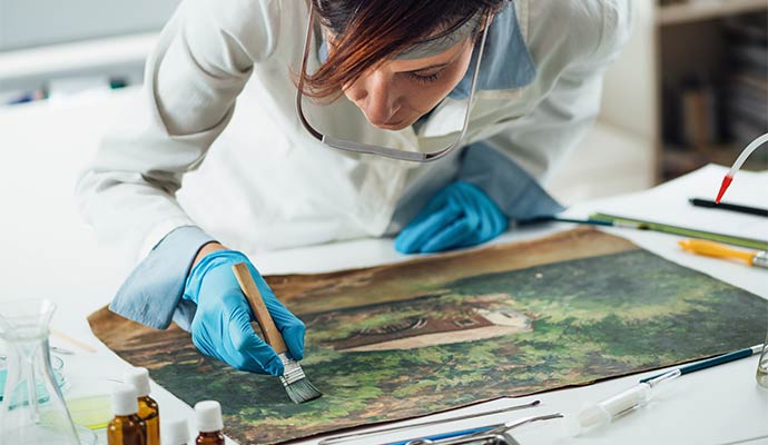 A person restoring soot damaged painting