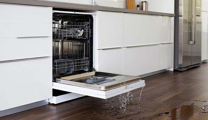 Open dishwasher leaking and dripping water onto kitchen floor