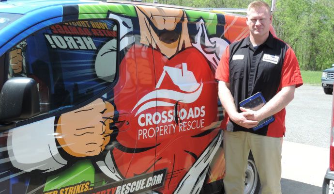 Crossroad service van with professional worker Professional worker standing next to Crossroad service van