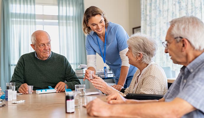 Nurse assisting elder persons in an assisted living facility