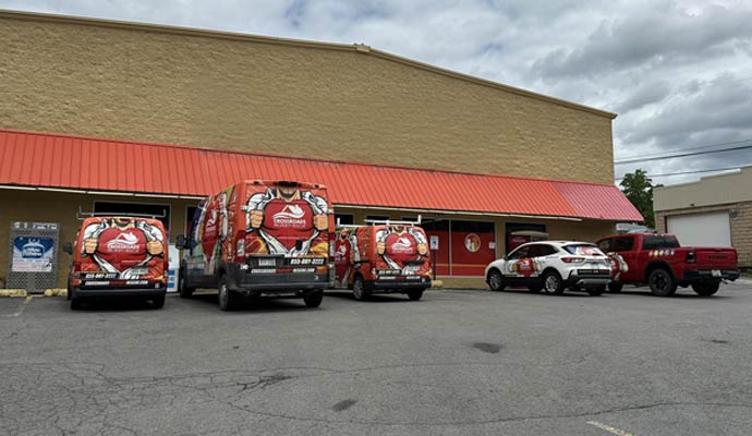 Vehicles of Crossroads Property Rescue parked at front of a commercial property