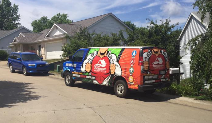 Crossroads Property Rescue service van parked in front of a residential home